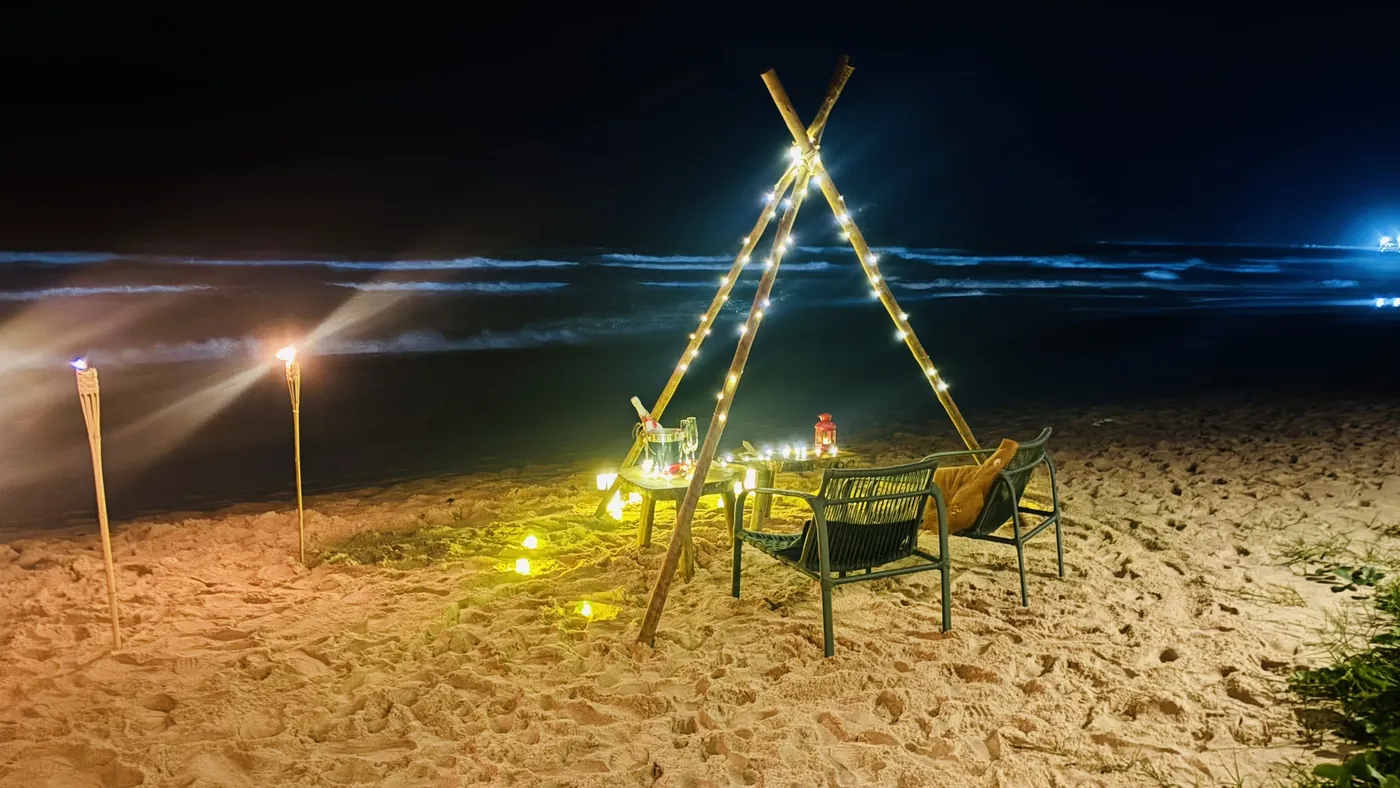 Jantar romântico à luz de velas montado na areia à noite