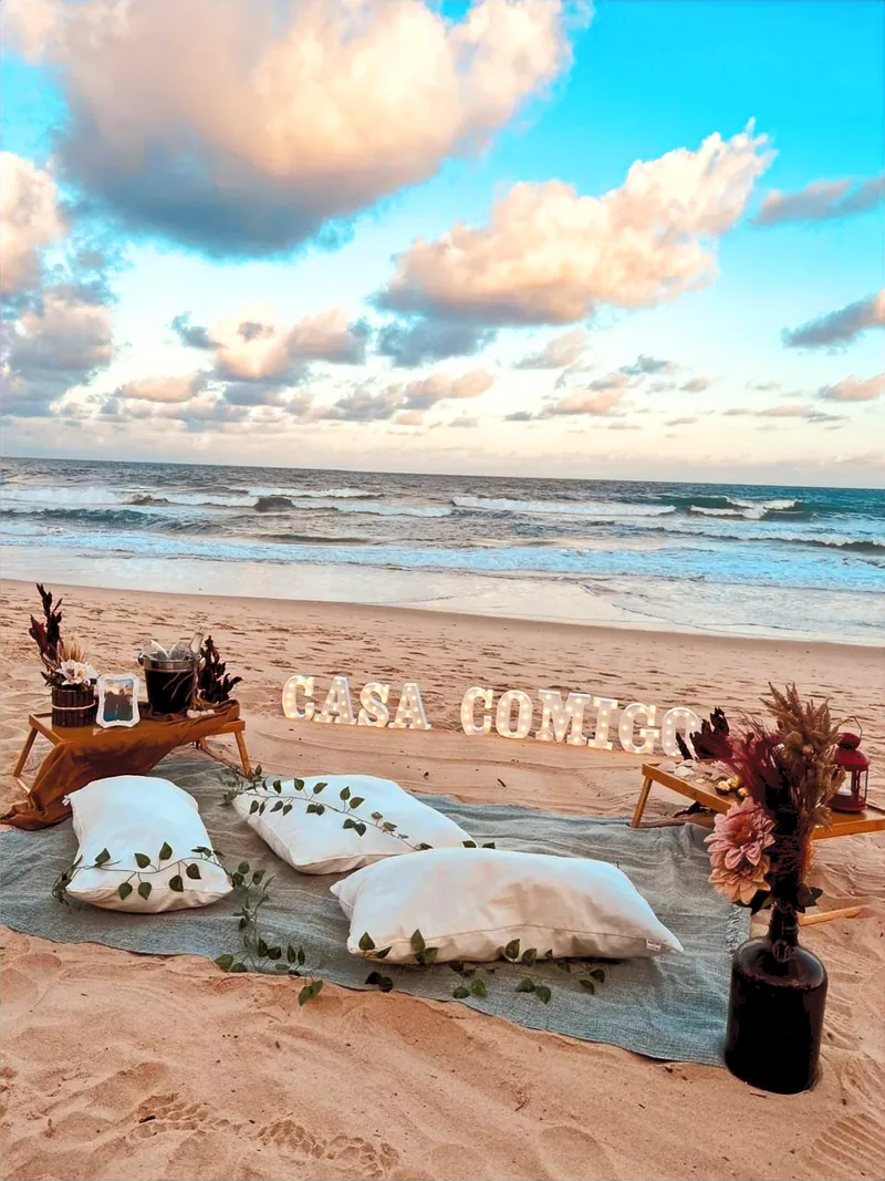 Cenário Casa Comigo montado na areia para pedido de casamento